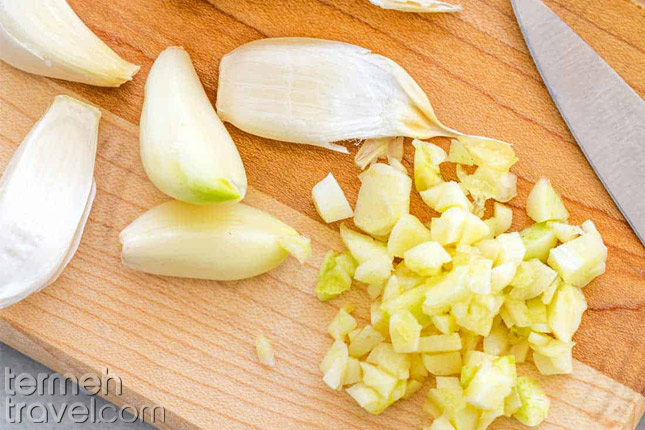 Garlic, diced on a wooden board- Termeh Travel 